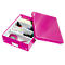 Pink storage box with an open lid, divided into compartments containing office supplies like a stapler and sticky notes.