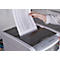 A person is placing a sheet of paper with text into a paper shredder. The shredder is grey, the paper white.