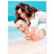 Happy couple at the beach: Man carries laughing woman on his shoulders.