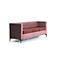 Modernes dreisitziges Sofa in verschiedenen Rot- und Rosatönen auf schlanken schwarzen Metallfüßen.