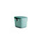 Mintgrüner, quadratischer Hocker mit Textilbezug und einem kleinen, schwarzen Ledergriff an der Seite.
