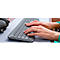 Hands typing on keyboard, ring on finger. Headphones in the background.