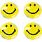 Vier gele smiley gezichten die vriendelijk glimlachen.
