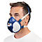 Un homme portant un masque respiratoire, masque bleu avec filtre blanc et sangles.