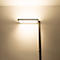 Moderne Stehleuchte mit flachem, rechteckigem Leuchtkopf, der warmes Licht an die Wand strahlt.