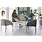 Twee mensen zitten in comfortabele fauteuils aan een tafel en praten vrolijk.