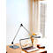Zilveren bureaulamp op tafel naast laptop, notitieboek en decoratie. Op de achtergrond een raam met gordijn.