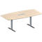 Una mesa ovalada de madera con patas de metal gris. En el centro hay una placa plateada.