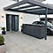 Dunkelgraue Mülltonnenbox unter einem Carport, vor einer Haustür. Das Bild ist aus der Perspektive des Betrachters aufgenommen.