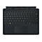 Schwarzes Surface Pro Keyboard mit integriertem Stift in der oberen Ablage auf weißem Hintergrund.
