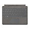 Dunkelgraue Microsoft Surface Tastatur von oben, mit integriertem Touchpad auf strukturiertem Stoffhintergrund.