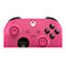 Gros plan sur une manette Xbox rose. Boutons et joysticks noirs, boutons colorés.