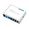 Ein weiÃŸer Router mit blauen Akzenten liegt auf einem weiÃŸen Hintergrund. Er hat mehrere AnschlÃ¼sse und die Aufschrift MikroTik RouterBOARD.