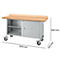 Werkbank met houten blad en metalen kast, afmetingen 1500 x 700 x 840 mm. Grijze deuren, open vakken en wielen.