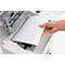 Hand placing paper into a printer. The printer is white, and the paper is blank.
