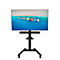 Schwarzer TV-Ständer mit Monitor. Auf dem Monitor sind Boote auf blauem Meer zu sehen.