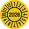 Gelbe runde Plakette mit schwarzer Umrandung und Zahlen: 2026 im Zentrum, Monate aussen.