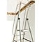Aluminium ladder voor witte muur, houten balken op de achtergrond.