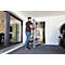 A man carries a foldable aluminium ladder through a doorway. Windows on the left, car on the right.