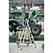 Een vrouw werkt aan een tractor, staand op een ladder. Ze draagt handschoenen.