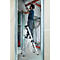Man op een ladder tijdens renovatiewerkzaamheden. Hij schildert een muur, met buizen en kabels op de achtergrond.