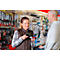Vendeuse scannant un produit, homme regardant. Dans un magasin d'outils.