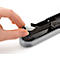Close-up of a hand inserting staples into a stapler. The stapler has a grey base and a black top.