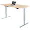 Un bureau réglable en hauteur avec un plateau de table brun clair et un cadre argenté. Un ordinateur portable est posé sur la table.