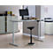 Un bureau réglable en hauteur avec un moniteur et une chaise dans un bureau moderne. Le bureau est gris, la chaise noire.
