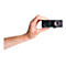 Une main tenant un projecteur noir sur fond blanc. L'objectif du projecteur est clairement visible.