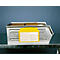 Metal box with yellow documents. Partially legible inscription. Box on table, blue background.