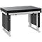 Een werkbanktafel met een zwarte geperforeerde plaat en grijze, stevige metalen poten, op een witte achtergrond.