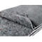 Grey, coarsely textured felt blanket, folded and slightly lifted. Interspersed with colored fiber remnants.