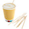 Tasse de café avec mousse de lait et bâtonnets en bois, tasse jaune. Sur fond clair.
