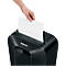 A hand placing a sheet of paper into a black Fellowes paper shredder.