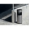 Gray trash can on a paved walkway next to a concrete pillar.