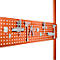 Orange pegboard with tools: pliers, wrench, and hooks.