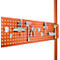 Orange pegboard with tools, hooks, and holders. The tools are arranged in a well-organized setup.