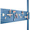 Blue pegboard with tools: screwdrivers, pliers, hammer, wrench and hooks.