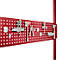 Red pegboard with tools and holders, such as hooks, clamps, pliers, and wrenches.