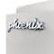 Nahaufnahme des verchromten Phoenix-Logos auf einer hellgrauen, metallischen Oberfläche.