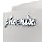 Nahaufnahme des verchromten Phoenix-Logos in Schreibschrift auf einer hellgrauen, metallischen Oberfläche.