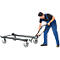 A man in blue work clothes operates a transport trolley. The trolley is loaded.