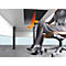 Une femme est assise à un bureau, les pieds sur le sol. Sous la table : chauffage avec des flèches indiquant la chaleur.