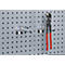 Grey pegboard with metal hooks. Pliers with red handles hang on a hook.