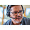 A man wearing glasses and a headset is speaking. He is looking slightly to the side.