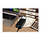 Ein schwarzes Laptop-LadegerÃ¤t liegt auf einem Schreibtisch, neben Laptop, Ordnern mit Beschriftung und einem Taschenrechner.