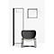Chaise design noire sur fond blanc. Aussi, un porte-vêtements, un cadre avec un arc.