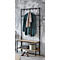 Porte-manteau avec cadre en métal, étagères en bois et vêtements. Mur gris en arrière-plan.