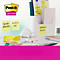 Un bureau avec des notes autocollantes et un support. Il y a des puces sur les notes. En arrière-plan, une pancarte avec Post-it.
